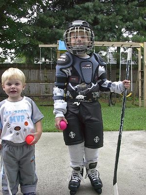 Conner getting outfitted for hockey and Jace helping out  2 Sep 2003
